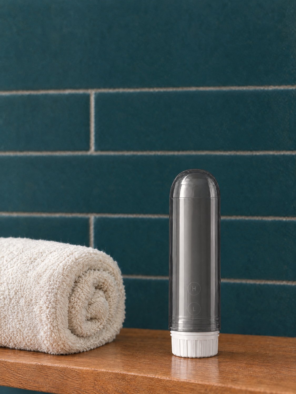 Closed bidet on a bathroom shelf beside a towel
