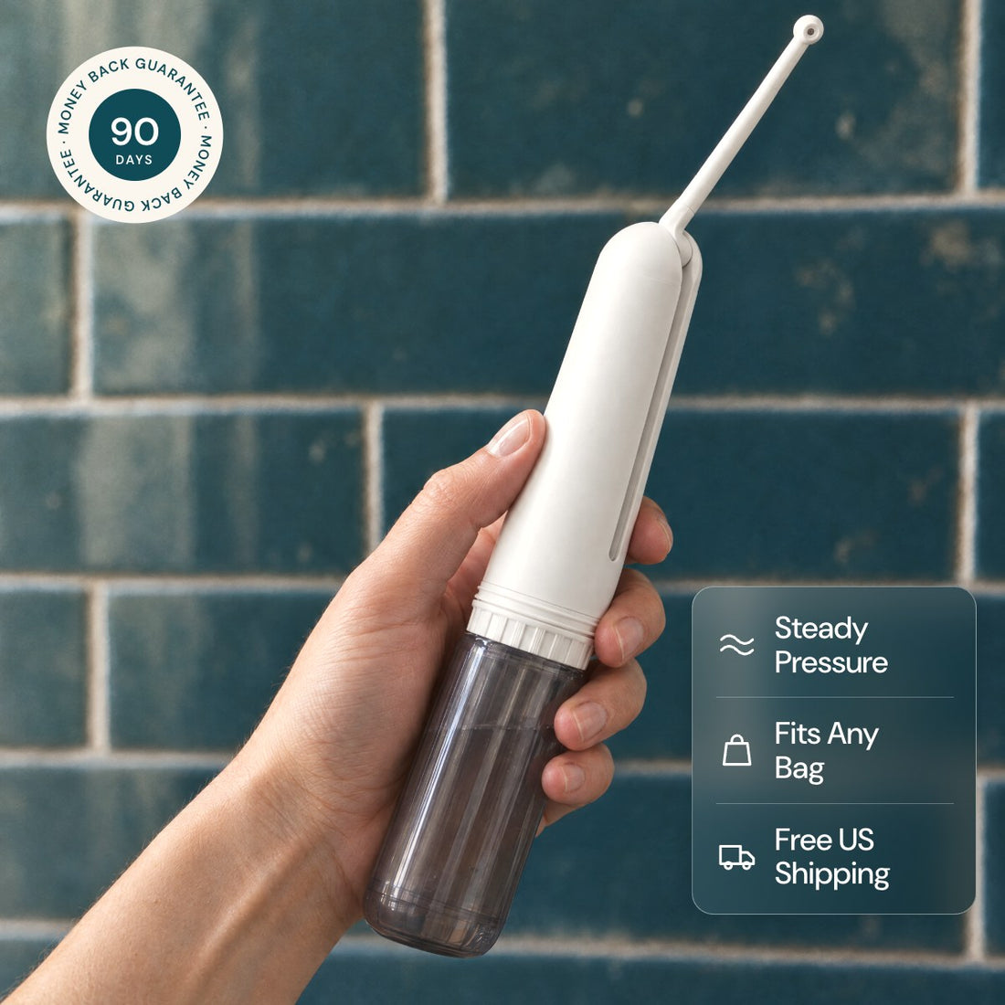 Hand holding the Caboose portable electric bidet in a bathroom, with 90 day money back guarantee