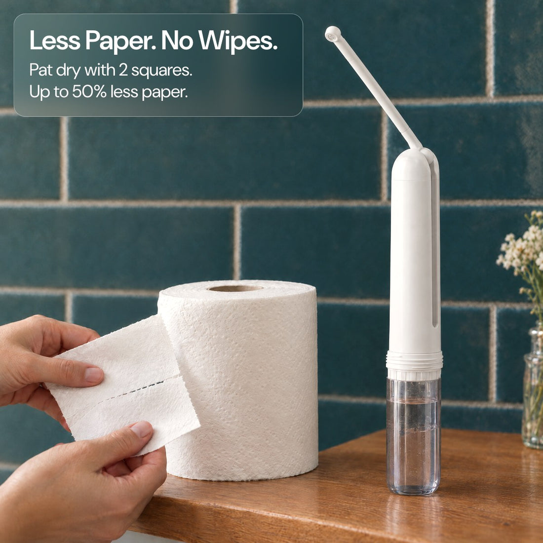 Hands tearing two squares of toilet paper beside the bidet